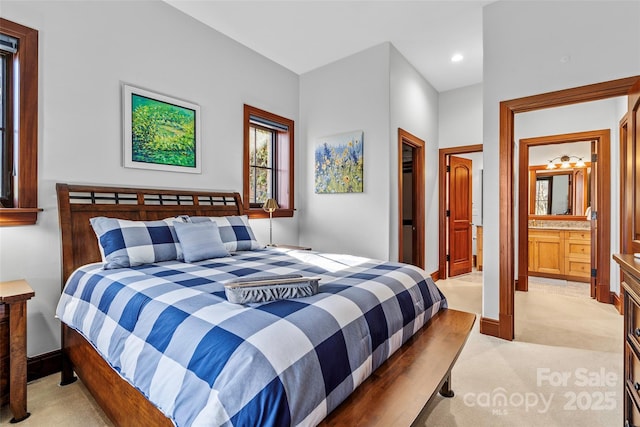 bedroom featuring light carpet and ensuite bathroom