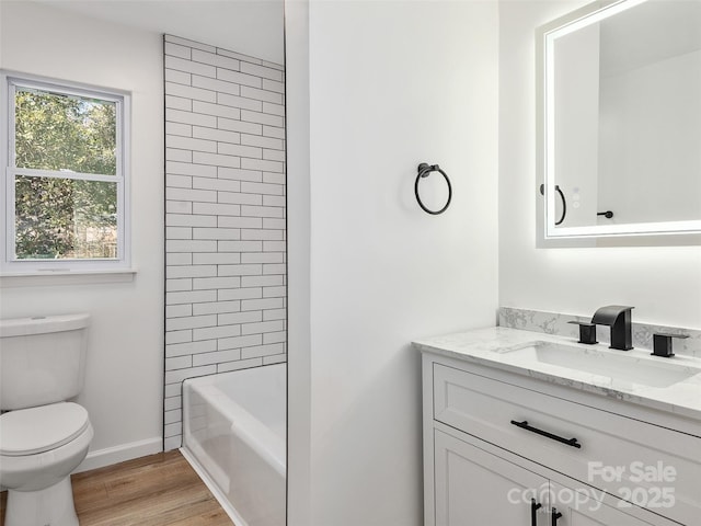 bathroom with hardwood / wood-style flooring, vanity, and toilet