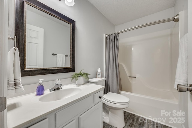 full bathroom with a textured ceiling, toilet, wood-type flooring, shower / bath combo with shower curtain, and vanity