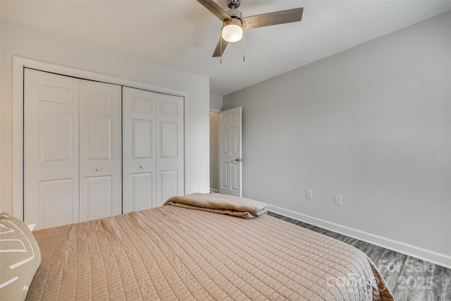 unfurnished bedroom with ceiling fan, a closet, a textured ceiling, and wood-type flooring