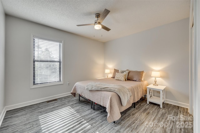 bedroom featuring a textured ceiling, ceiling fan, and hardwood / wood-style flooring