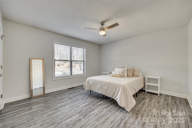 bedroom featuring hardwood / wood-style floors, a textured ceiling, and ceiling fan