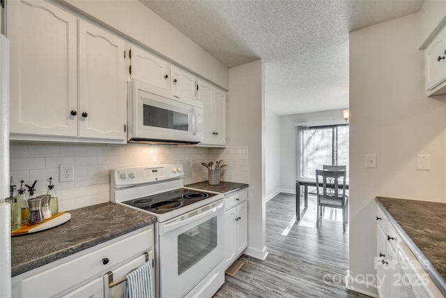 kitchen featuring white appliances, white cabinets, and tasteful backsplash