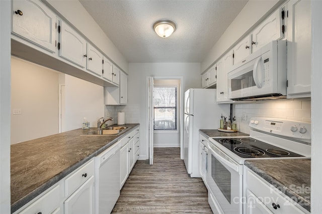 kitchen with sink, white cabinets, a textured ceiling, white appliances, and decorative backsplash