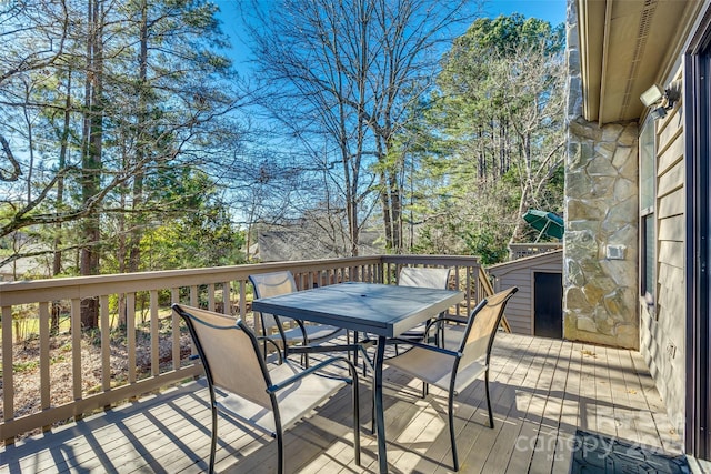 wooden deck featuring a storage unit