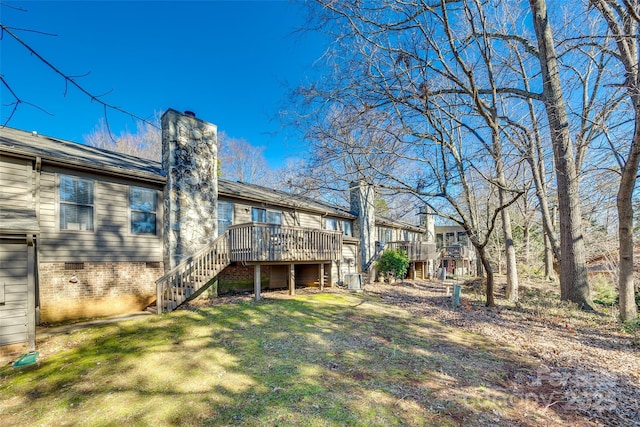 rear view of property featuring a yard and a wooden deck