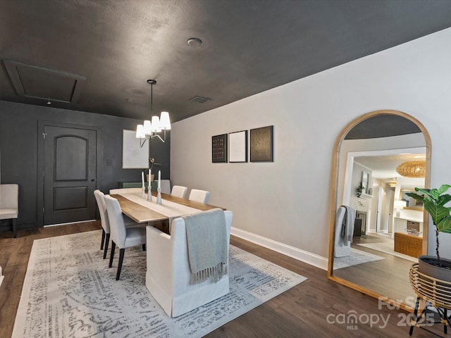 dining space with dark hardwood / wood-style floors and a notable chandelier