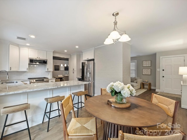 dining space featuring sink and light wood-type flooring