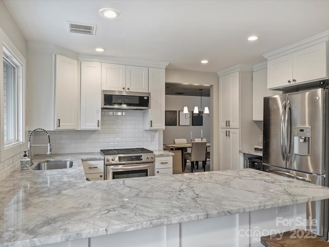 kitchen featuring white cabinetry, appliances with stainless steel finishes, sink, and kitchen peninsula