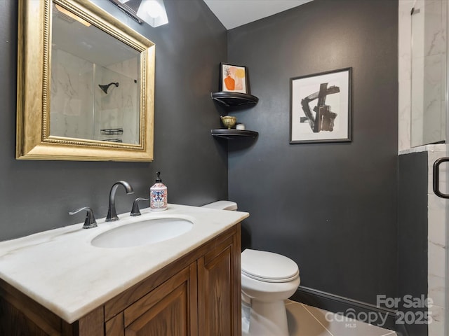 bathroom featuring vanity, a shower with shower door, and toilet