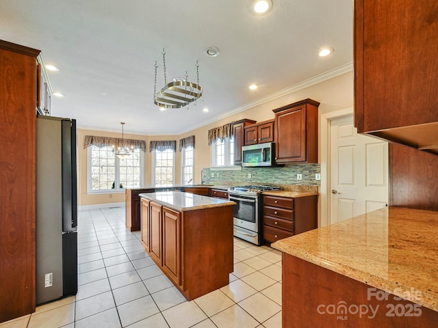 kitchen featuring kitchen peninsula, appliances with stainless steel finishes, light stone counters, crown molding, and a kitchen island