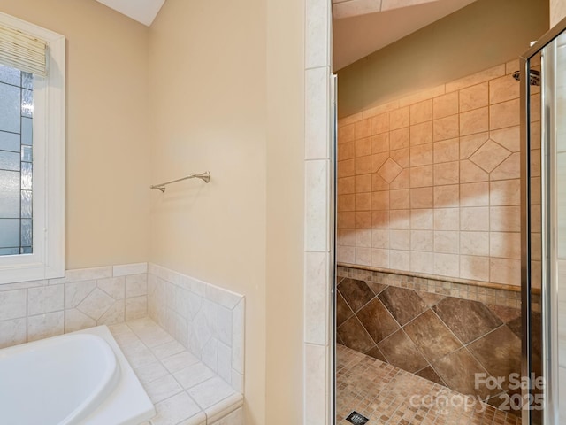 bathroom with plus walk in shower and a healthy amount of sunlight