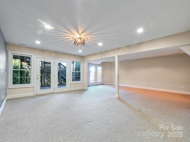 basement with plenty of natural light, carpet floors, and french doors