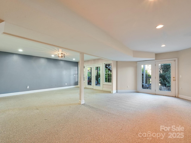 basement with french doors and light colored carpet