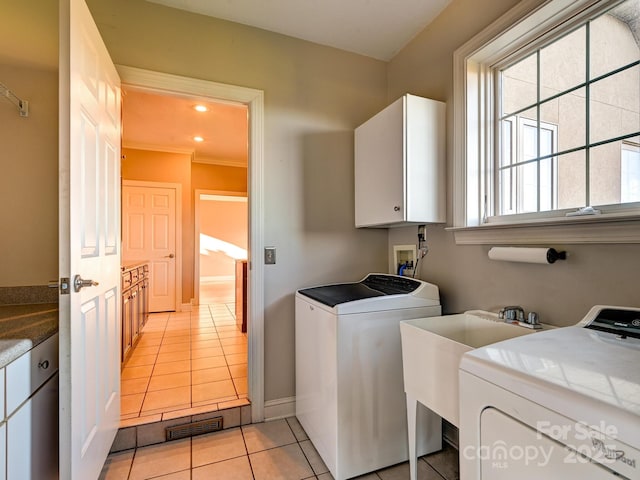 laundry room with cabinets, light tile patterned flooring, and washer and dryer