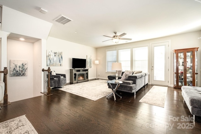 living room featuring ceiling fan and dark hardwood / wood-style floors