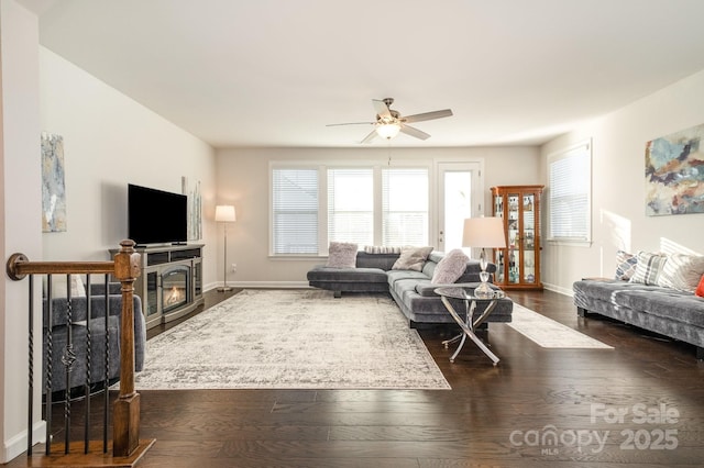 living room with ceiling fan, dark wood-type flooring, and a fireplace