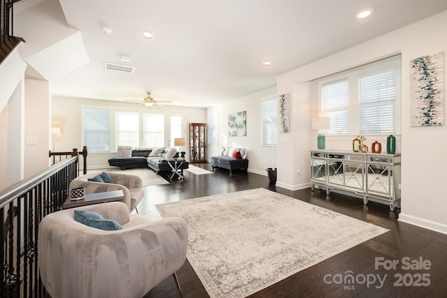 living room featuring ceiling fan and dark hardwood / wood-style floors