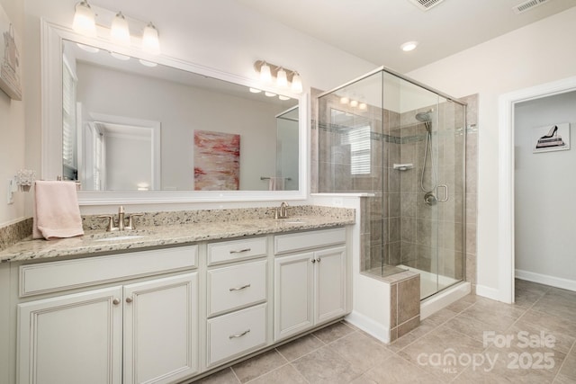 bathroom featuring tile patterned floors, an enclosed shower, and vanity