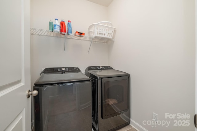 laundry room featuring tile patterned flooring and washer and clothes dryer