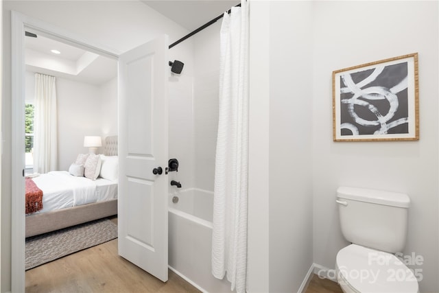 bathroom featuring hardwood / wood-style floors, toilet, and shower / bath combo with shower curtain