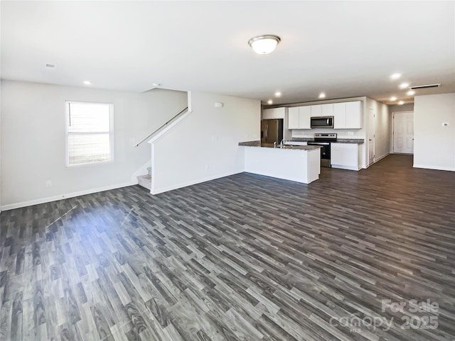 kitchen featuring a center island with sink, white cabinets, dark hardwood / wood-style floors, and appliances with stainless steel finishes