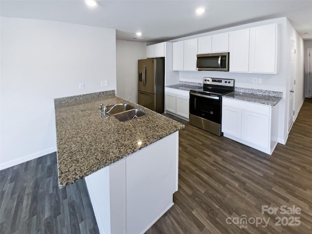 kitchen featuring kitchen peninsula, appliances with stainless steel finishes, dark hardwood / wood-style flooring, sink, and white cabinets