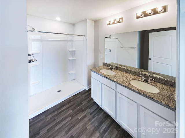 bathroom featuring hardwood / wood-style floors, vanity, and walk in shower