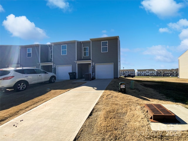 view of front facade featuring a garage and central AC unit