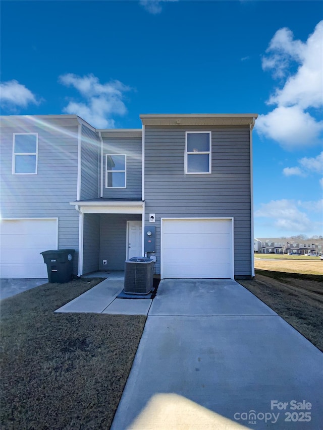 view of front of home featuring a garage and central air condition unit