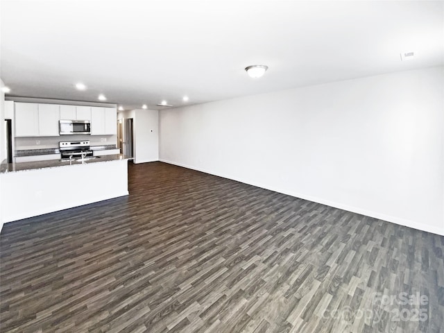 unfurnished living room featuring dark wood-type flooring