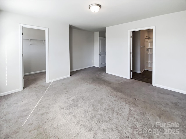 unfurnished bedroom featuring a walk in closet, ensuite bathroom, and a closet