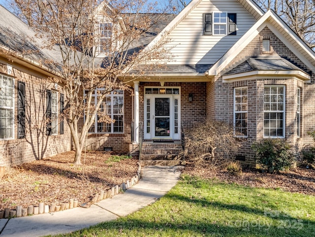 view of front of home featuring a shingled roof, crawl space, and brick siding