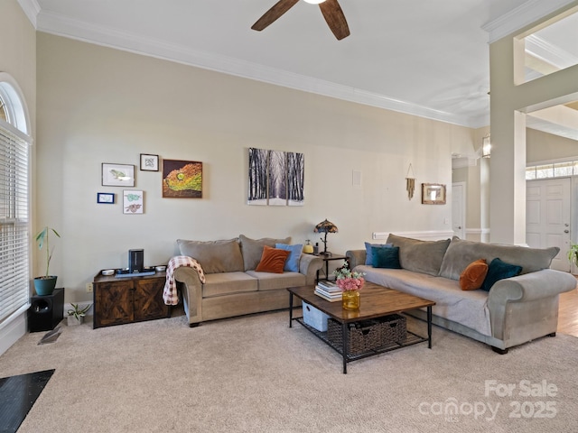 living room featuring ornamental molding, a ceiling fan, a wealth of natural light, and light colored carpet