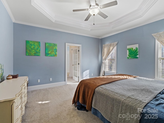 bedroom featuring ornamental molding, a tray ceiling, carpet flooring, and baseboards