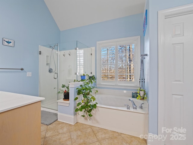 bathroom featuring a stall shower, tile patterned flooring, a garden tub, and vanity