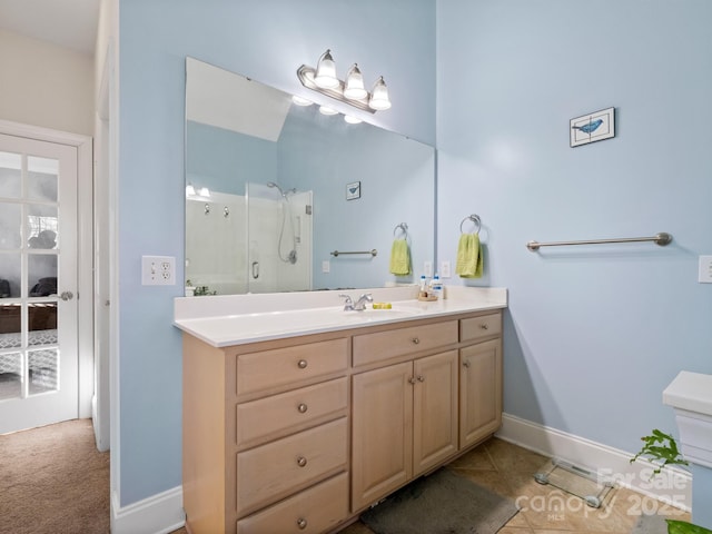 full bath with a stall shower, vanity, baseboards, and tile patterned floors