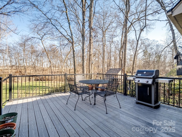 wooden terrace featuring outdoor dining area and grilling area