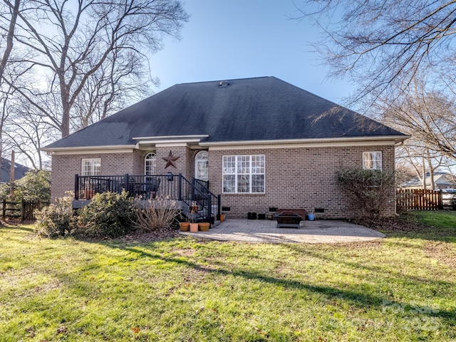 rear view of property featuring brick siding, a patio, a lawn, crawl space, and fence