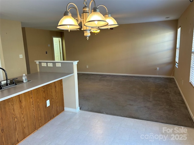 kitchen with light carpet, an inviting chandelier, and hanging light fixtures