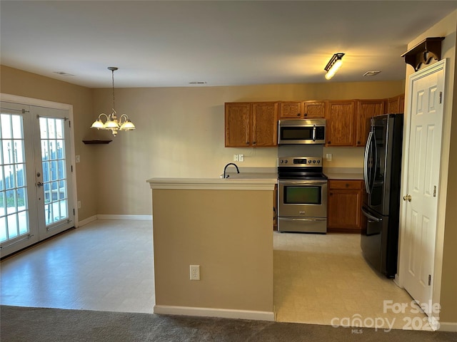 kitchen with kitchen peninsula, french doors, stainless steel appliances, an inviting chandelier, and hanging light fixtures