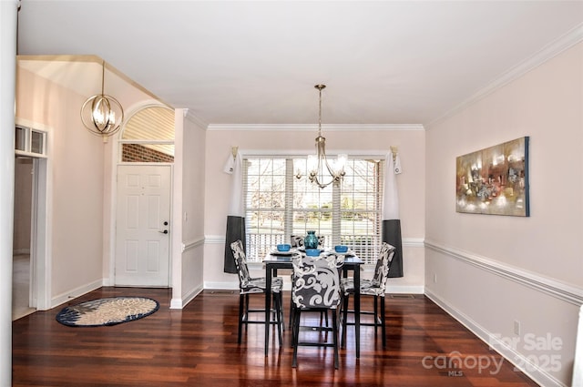 dining area featuring ornamental molding, dark hardwood / wood-style flooring, and a chandelier