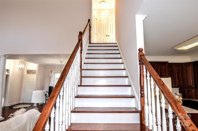 stairs with an inviting chandelier and crown molding