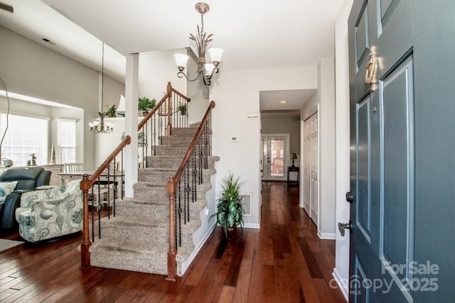 entrance foyer with a high ceiling, dark hardwood / wood-style floors, and a notable chandelier