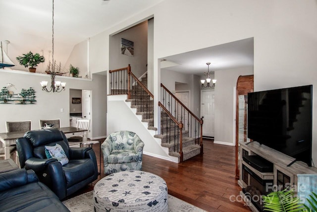 living room featuring a high ceiling, dark hardwood / wood-style floors, and an inviting chandelier