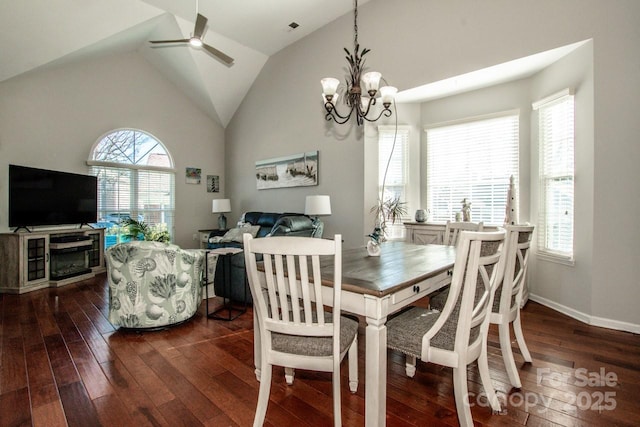 dining area with vaulted ceiling, ceiling fan with notable chandelier, and dark hardwood / wood-style floors