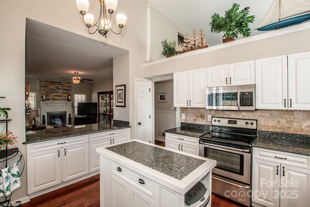 kitchen with ceiling fan with notable chandelier, hanging light fixtures, decorative backsplash, white cabinetry, and stainless steel appliances