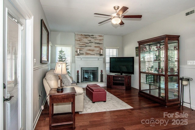 living room featuring a fireplace, dark hardwood / wood-style flooring, and ceiling fan