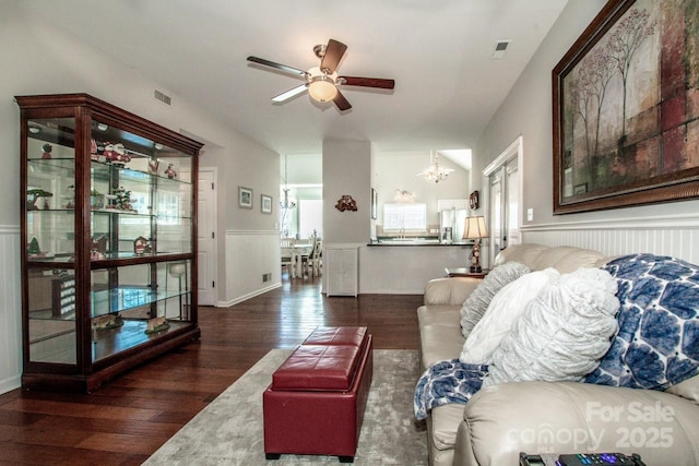 living room featuring ceiling fan with notable chandelier and dark hardwood / wood-style floors