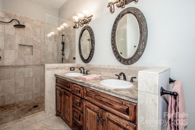 bathroom featuring backsplash, a tile shower, vanity, tile walls, and tile patterned flooring